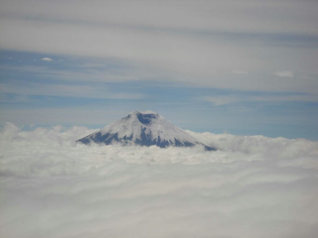 The peak of Cotopaxi Volcano can be seen through the clouds in Ecuador