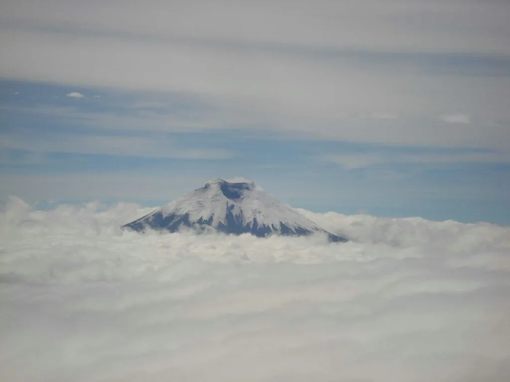The peak of Cotopaxi Volcano can be seen through the clouds in Ecuador
