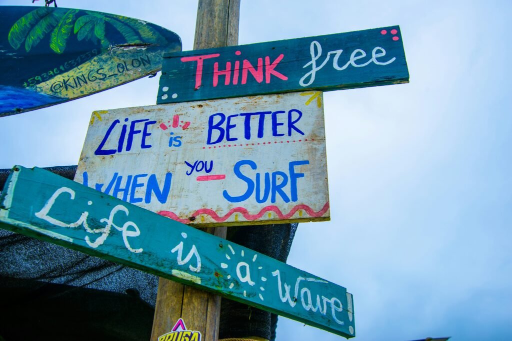 A jumble of hand painted signs reading: “Life is better when you surf,” and “Life is a wave” in Olón, Ecuador.