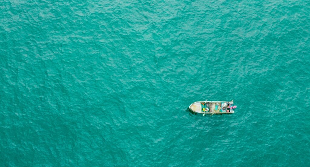 A fishing boat sails through the bright blue Pacific Ocean, Ecuador. Wheely Tyred Best places to eat in Olón