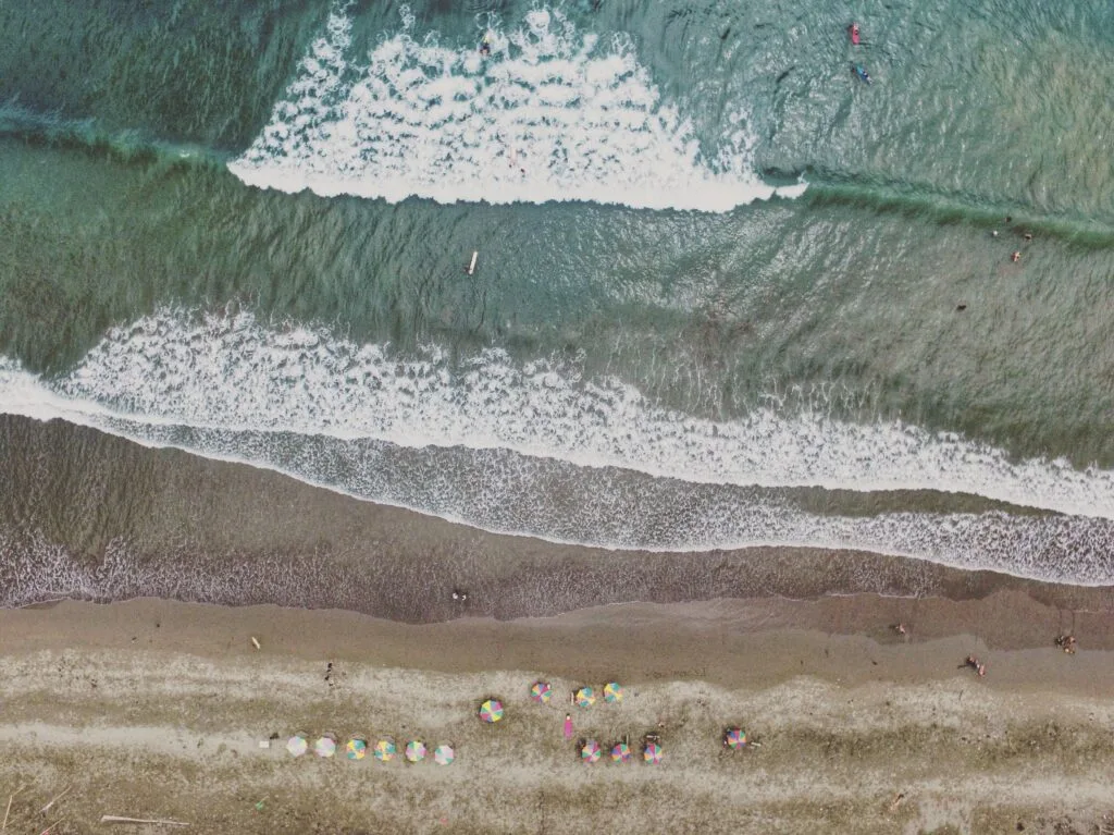 Waves crash against a beach in an aerial shot.