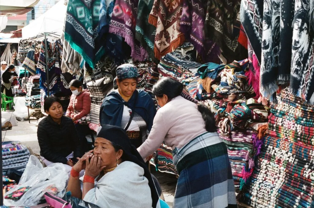 Indigenous women shop in Plaza de Ponchos in Otavalo, Ecuador.