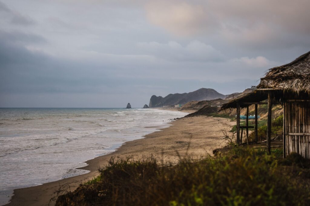 A beach and headland on a grey day in Manabí, Ecuador.