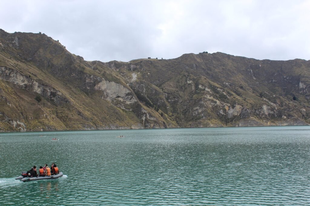 A boat floats in a blue caldera lake at Quilotoa, Ecuador