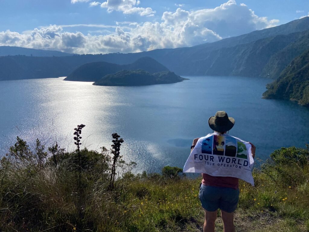 A man stands looking out over the islands in Lake Cuicocha in Ecuador. Wheely Tyred Best Otavalo multi-day tours