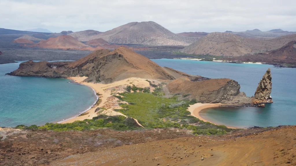 A peninsula of volcanic rock on the Ecuadorian Islands with Pinnacle Rock on display. Wheely Tyred best Galápagos boat tours