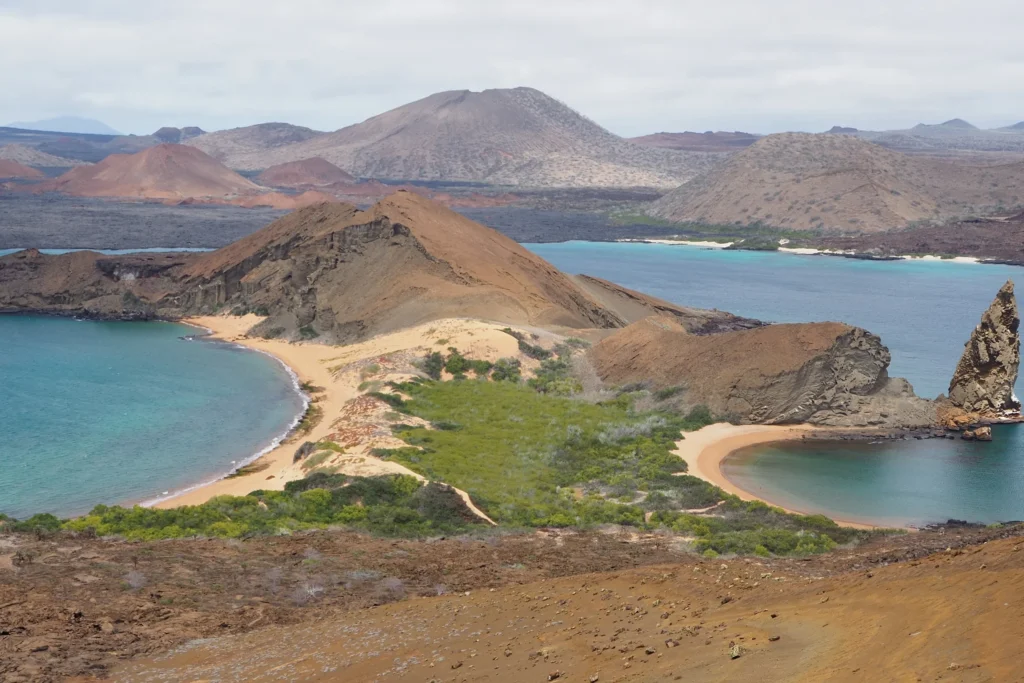 A peninsula of volcanic rock on the Galápagos Islands with Pinnacle Rock on display.