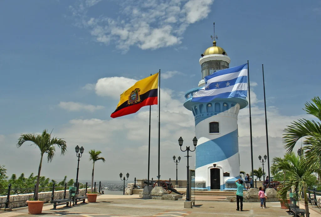 The blue and white lighthouse with the flags of Ecuador and the city flying in the wind. Wheely Tyred best Guayaquil bus tours