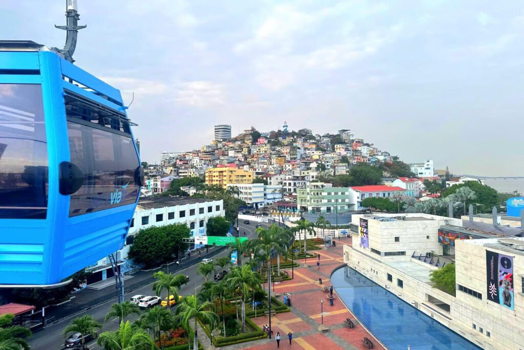 A blue cable car moves towards the colourful district of Las Peñas in Guayaquil, Ecuador