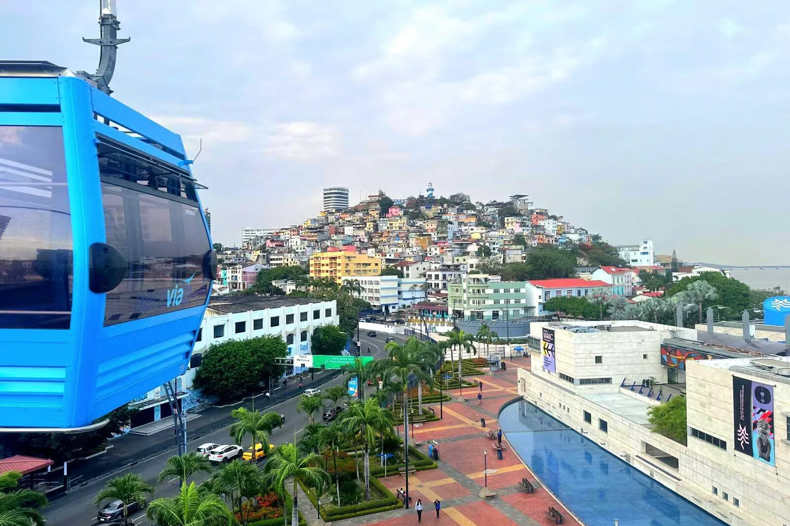 A blue cable car moves towards the colourful district of Las Peñas in Guayaquil, Ecuador