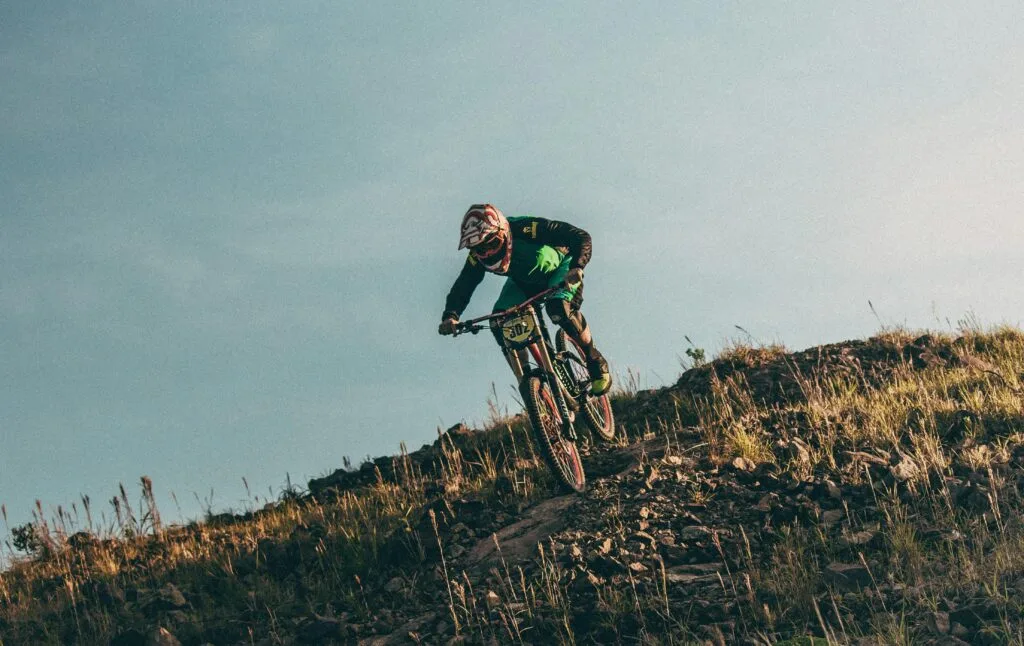 A mountain biker crests a hill in the air on Chimborazo, Ecuador