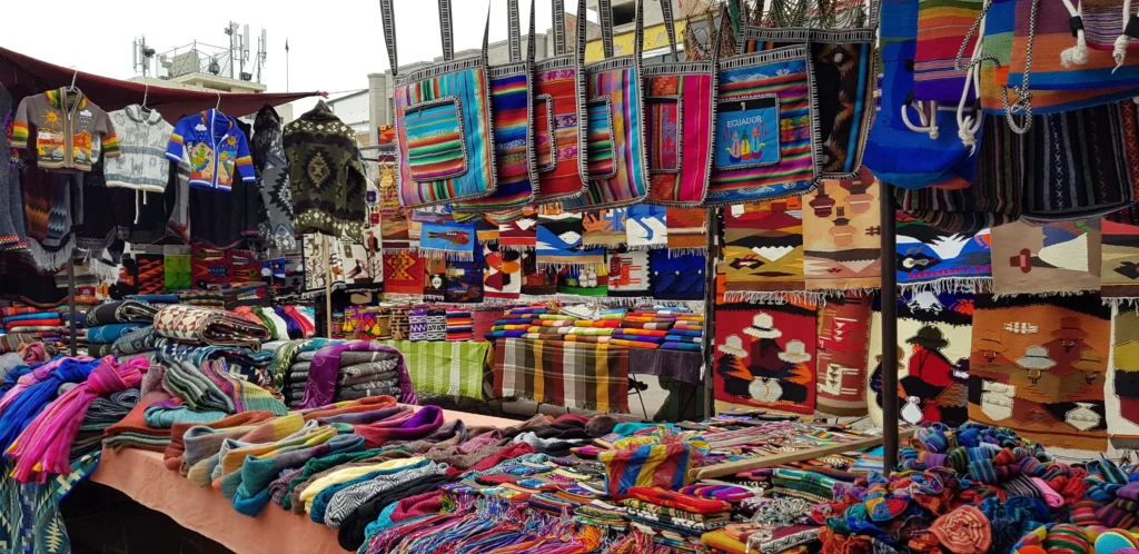 A range of multicoloured indigenous crafts on a stall in Plaza de Ponchos, Otavalo, Ecuador
