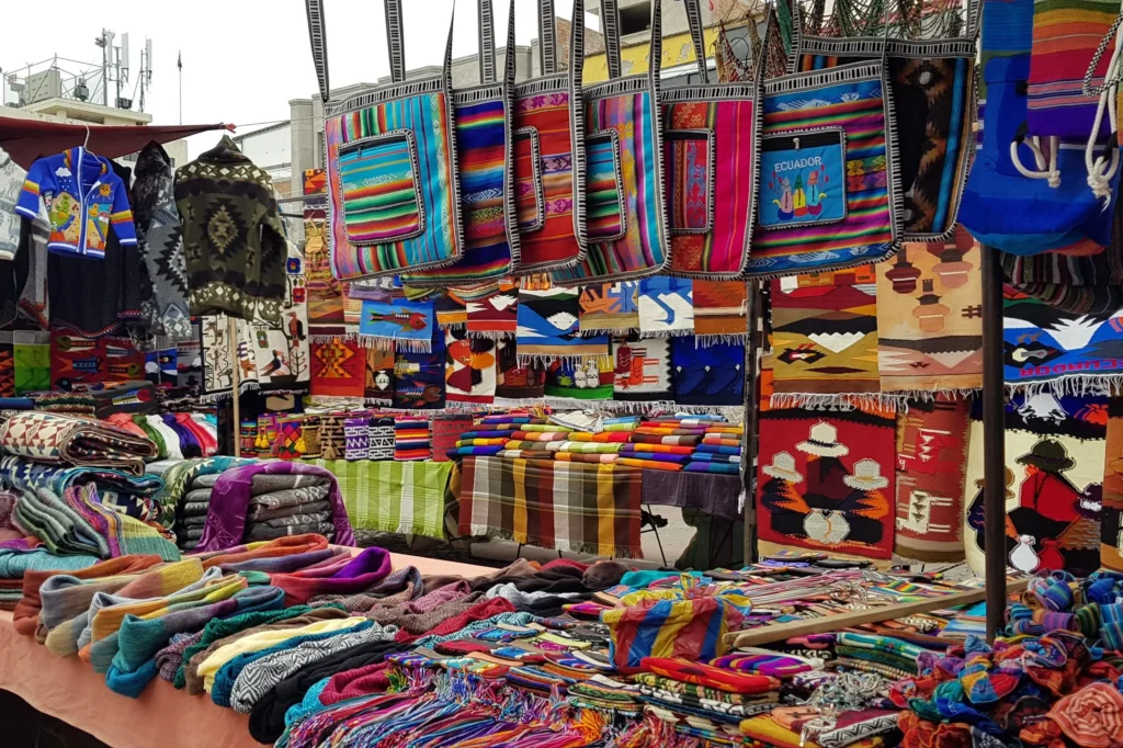 Una selección de artesanía indígena de colores variados en un puesto de la Plaza de Ponchos, en Otavalo, Ecuador