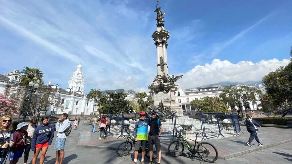 A guide and tourist pose with e-bikes in the historic centre of Ecuador. Wheely Tyred Best Quito bike tours