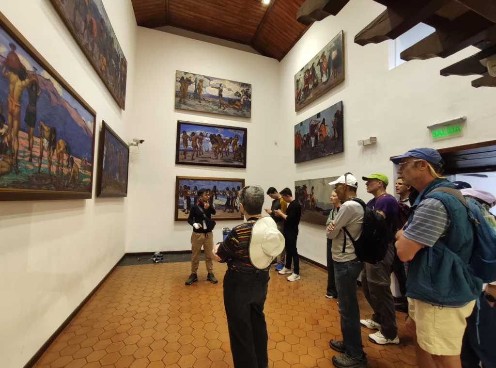 A tour guide shows a group some pictures in a gallery in Quito. Wheely Tyred walking tours in Ecuador’s Sierra