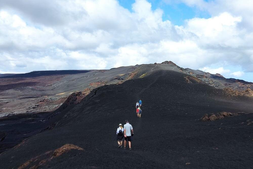 People hike to the caldera of Sierra Negra volcano on Isla Isabela, Galápagos Islands