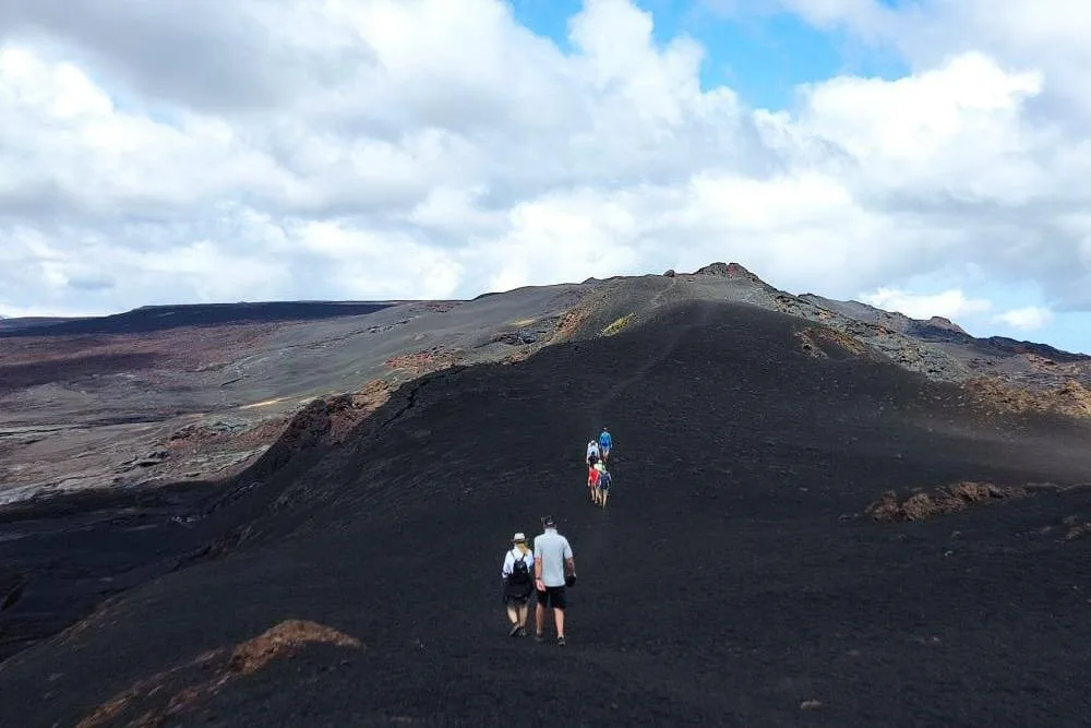 People hike to the caldera of Sierra Negra volcano on Isla Isabela, Galápagos Islands