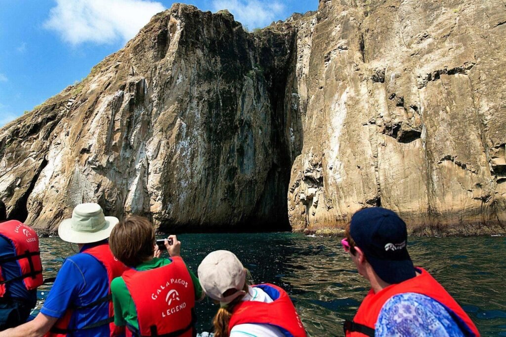 People in red life jackets look up at Kicker Rock from the water near San Cristobal. Wheely Tyred best Galápagos boat tours
