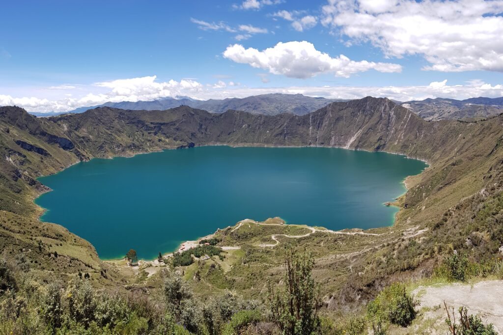 A crater lake is emerald under the sun at Lake Quilotoa, Ecuador