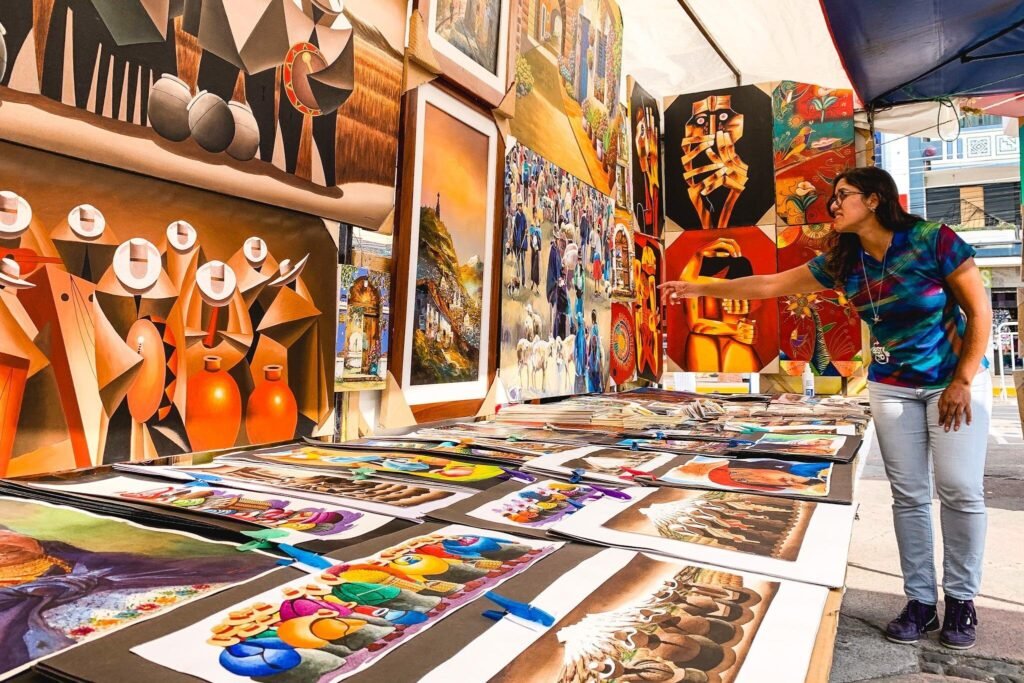 A lady points at paintings in an art shop in Otavalo, Ecuador