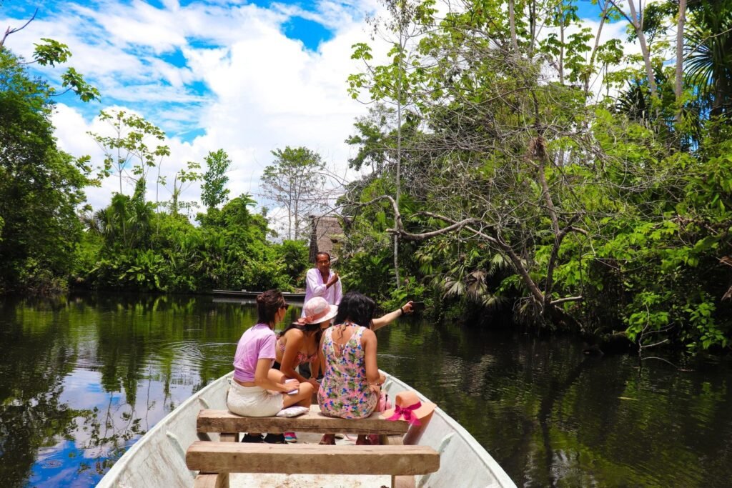 People drift on a boat through the Amazon with a guide explaining what they’re seeing, near Tena, Ecuador