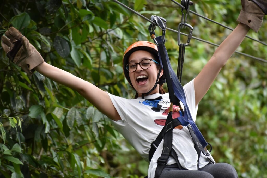 A woman slides along a zipline with her hnads up in Mindo, Ecuador