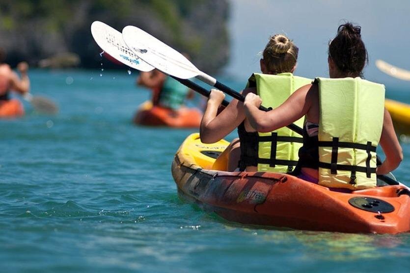 People kayak through the Pacific Ocean off a beach at Machalilla, Puerto Lopez, Ecuador