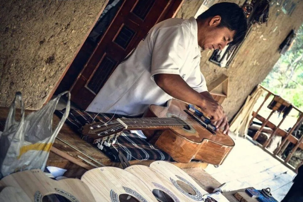 A guiter maker works on a wooden body in San Bartolome, near Cuenca, Ecuador