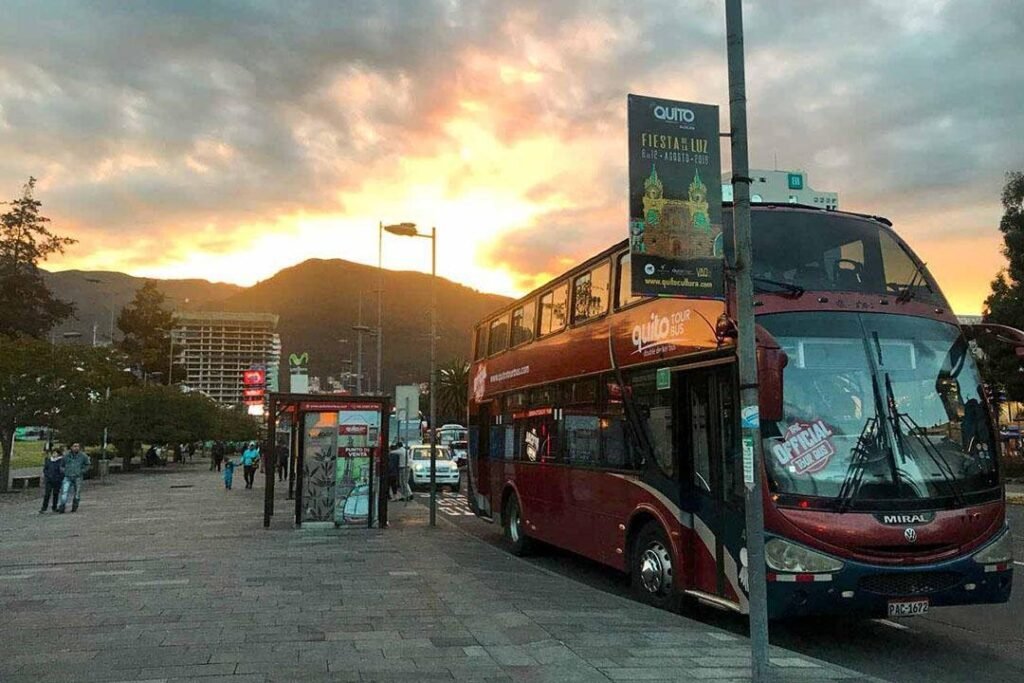 The sun sets behind a hop-on hop-off tour bus in Quito, Ecuador