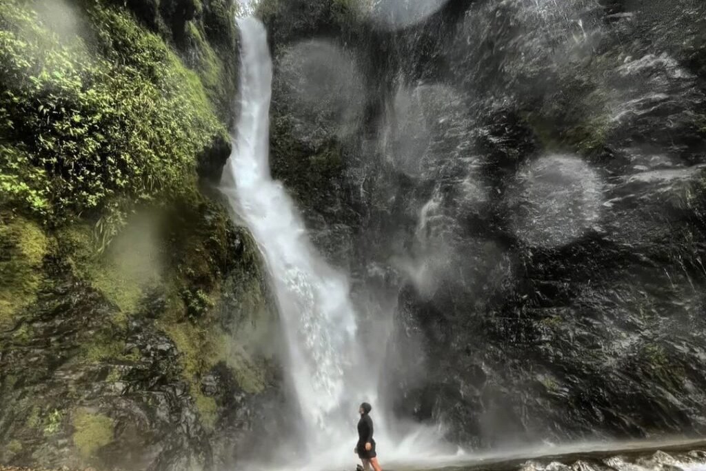 A person stands in front of a huge waterfall near Guayaquil, Ecuador