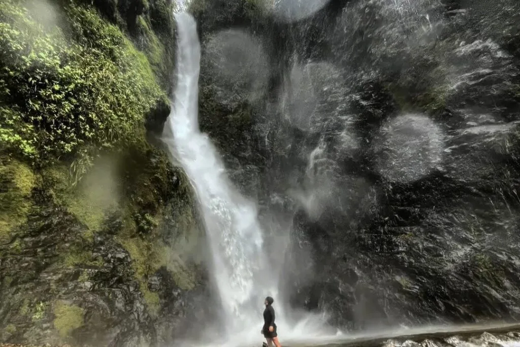 A person stands in front of a huge waterfall near Guayaquil, Ecuador