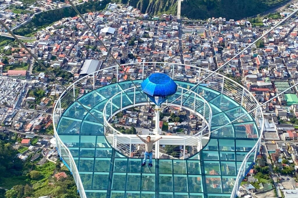 A man stands on the glass platform on the huge swing in Baños, Ecuador