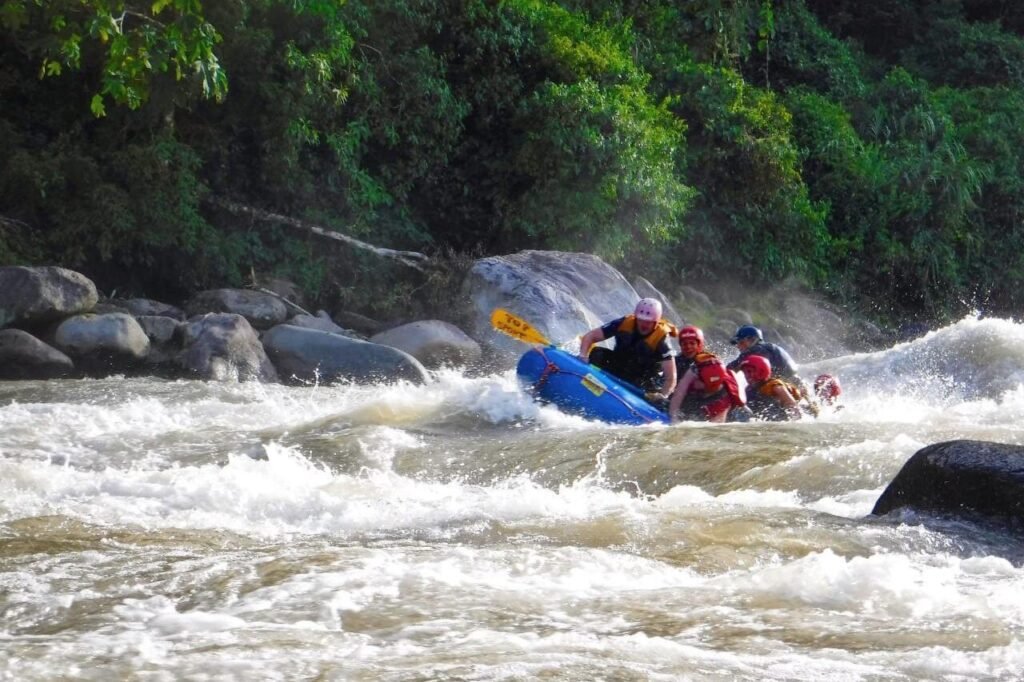 A raft bounces through white water on a river in Ecuador. Wheely Tyred Baños boat tours