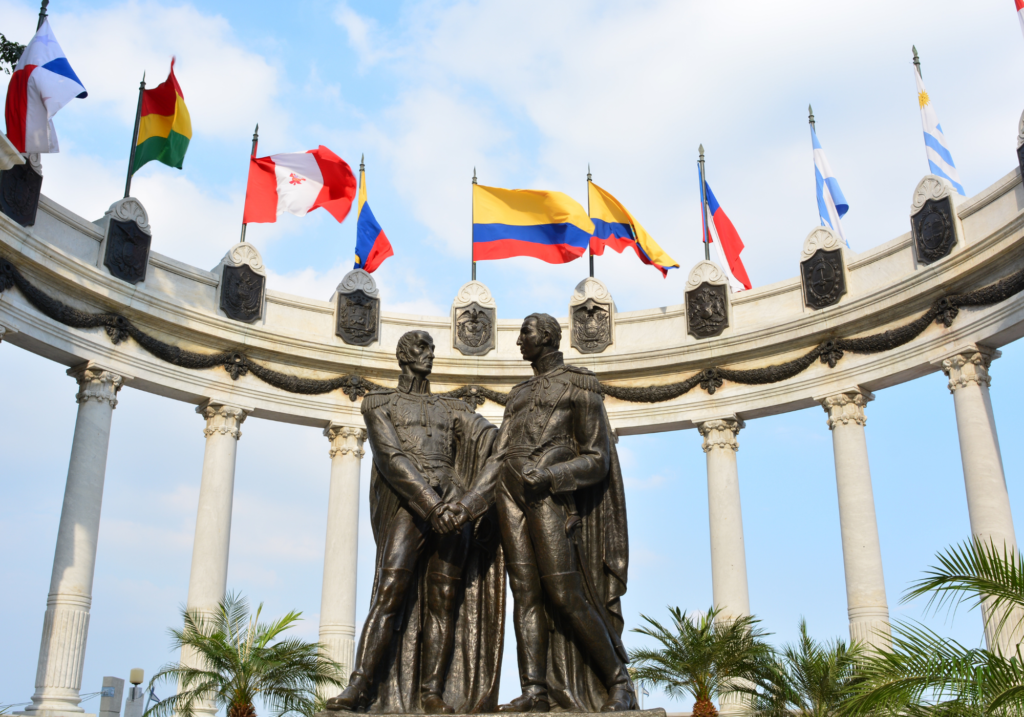 A statue of two men surrounded by flags in Ecuador. Wheely Tyred Best Guayaquil food tours