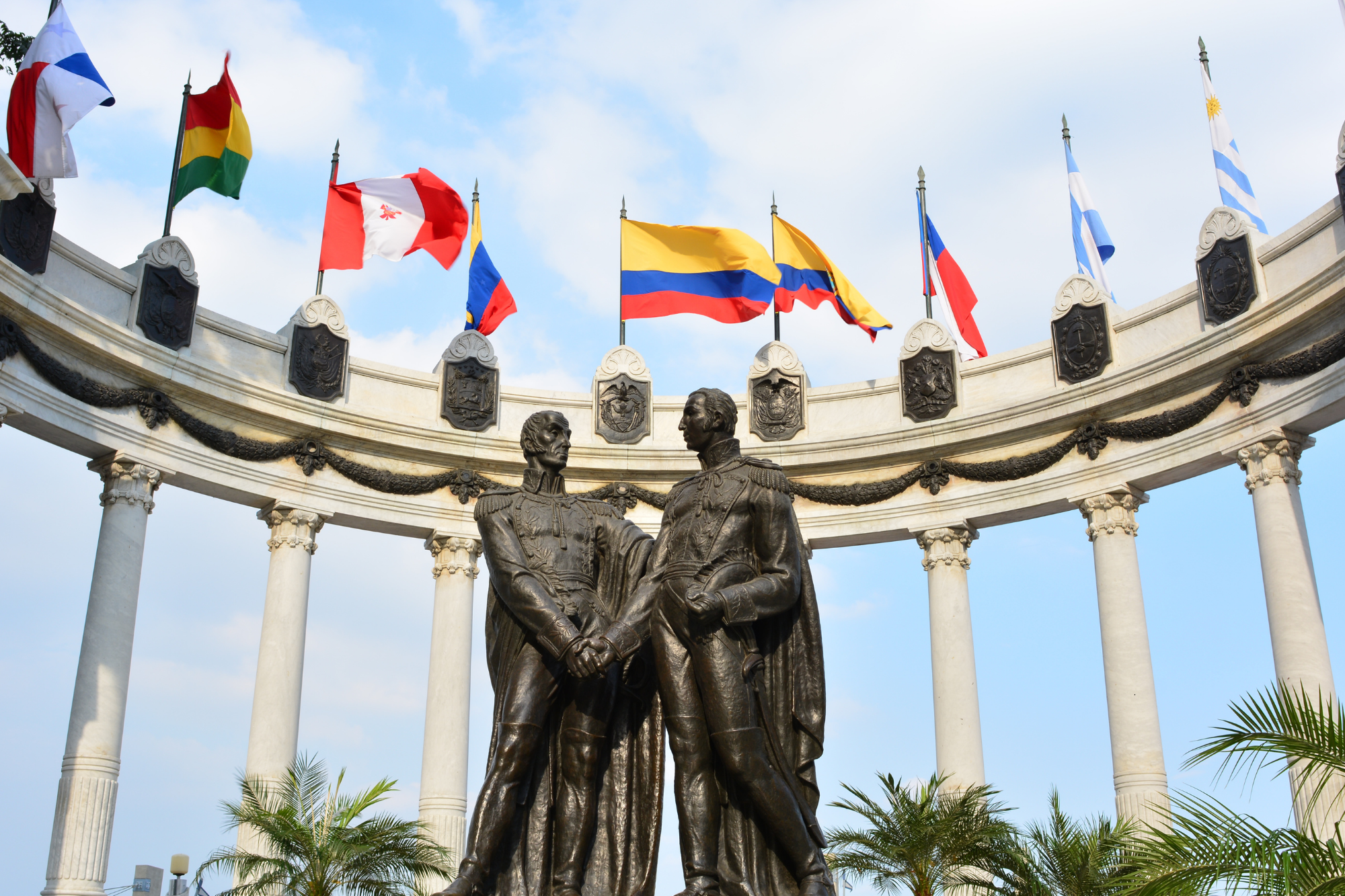 A statue of two men surrounded by flags in Guayaquil, Ecuador