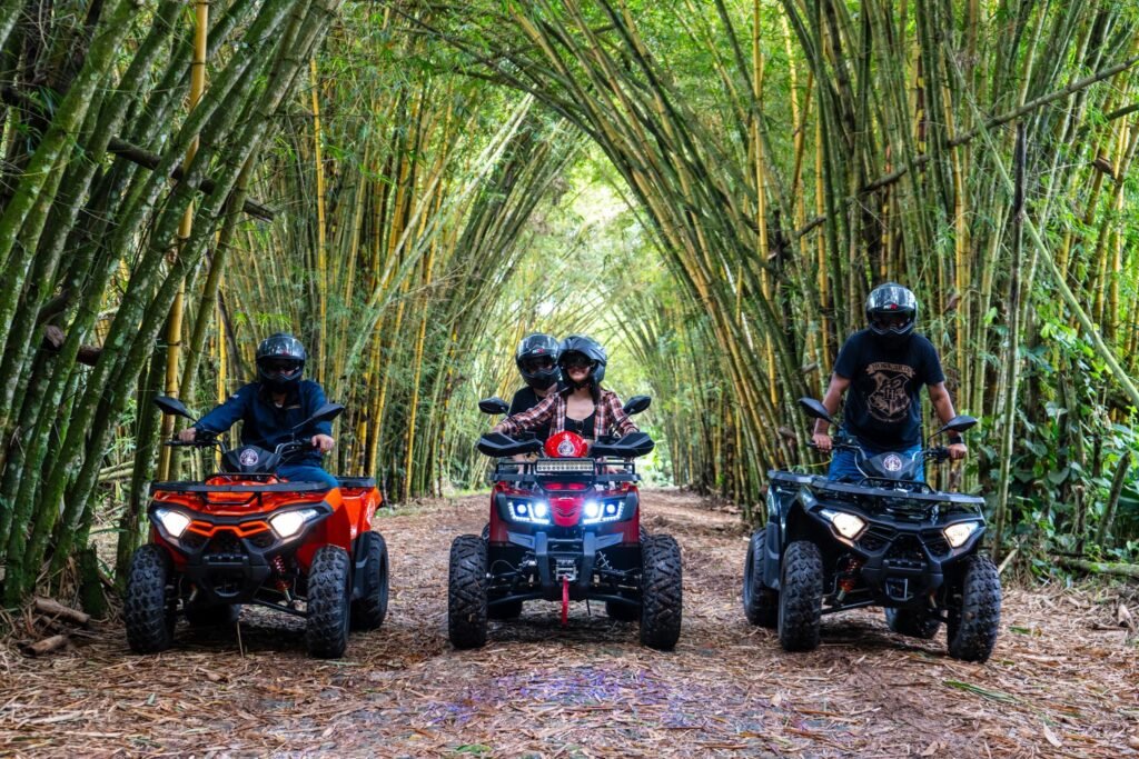 Three quad bikes with lights on surrounded by bamboo in the Amazon near Tena, Ecuador