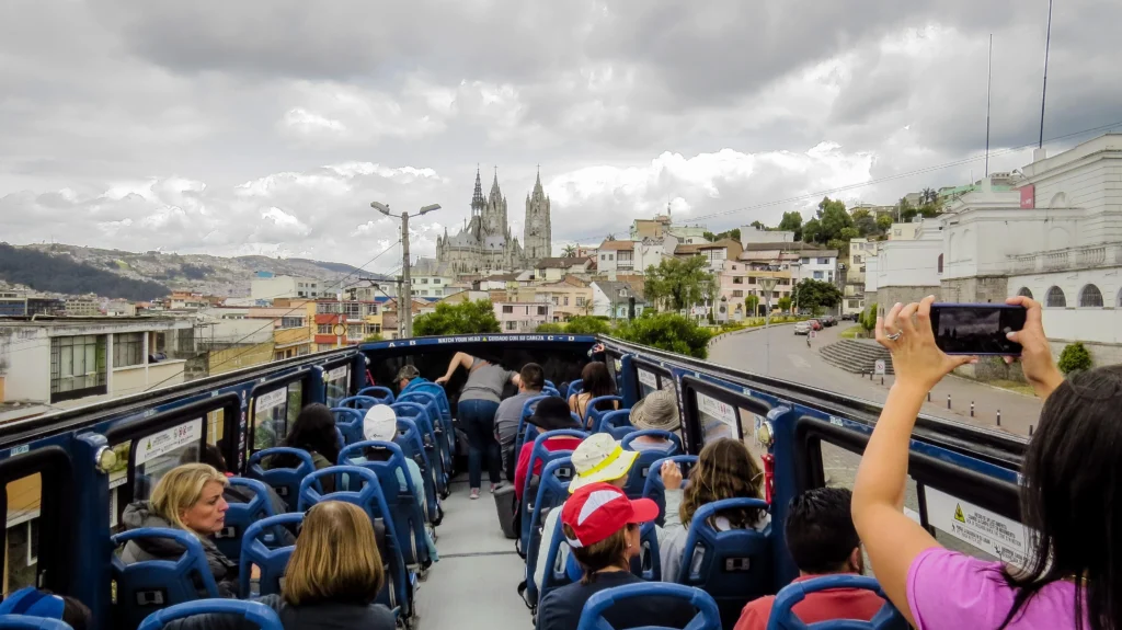 People look at the Basílica del Voto Nacional from the top deck of a tour bus in Quito. Wheely Tyred Best bus tours in the Sierra Ecuador