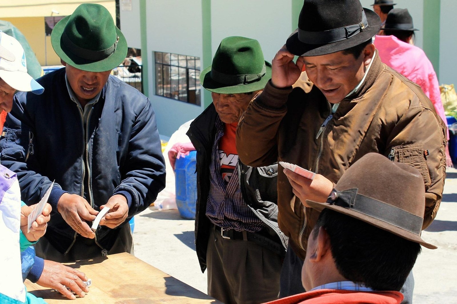 Indigenous Ecuadorian men discuss making a purchase in a market in Zumbahua, Ecuador