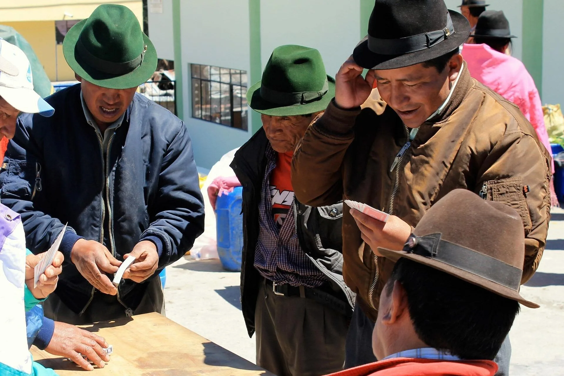 Indigenous Ecuadorian men discuss making a purchase in a market in Zumbahua, Ecuador