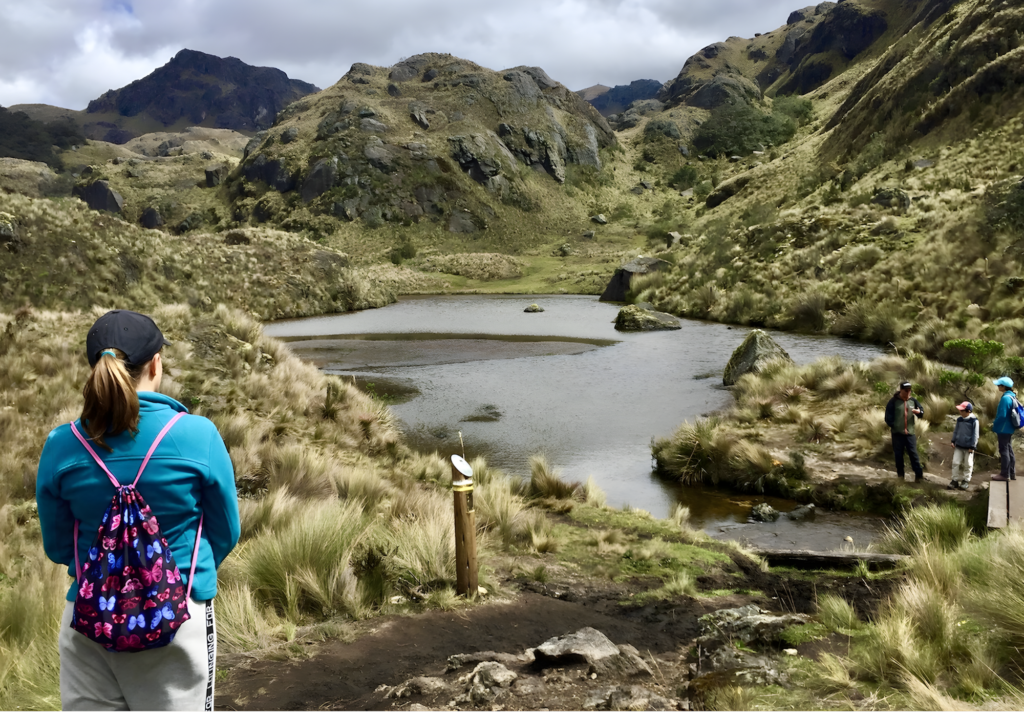 A woman in hiking gear looks at a lake in Cajas National Park, Cuenca, Ecuador