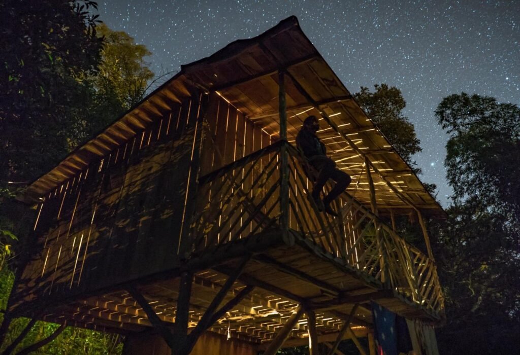 A person sits on the balcony of Rumi Wilco Ecolodge under the stars near Loja, Ecuador
