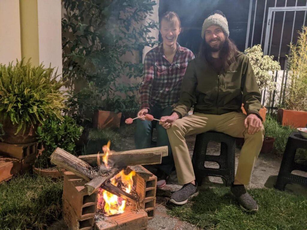 A couple roast marshmallows over an open fire in Cuenca, Ecuador