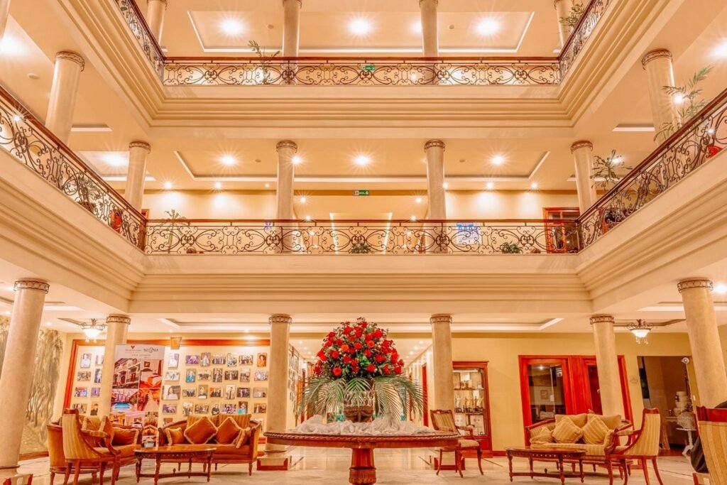 The bright, cream interior of the Grand Victoria Boutique Hotel in Loja, Ecuador, has a huge bouquet of red flowers