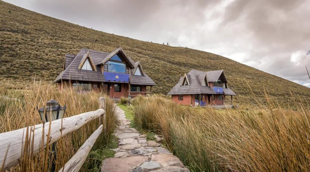 Two lodges surrounded by tall, wild grass on the slopes of Chimborazo, Ecuador