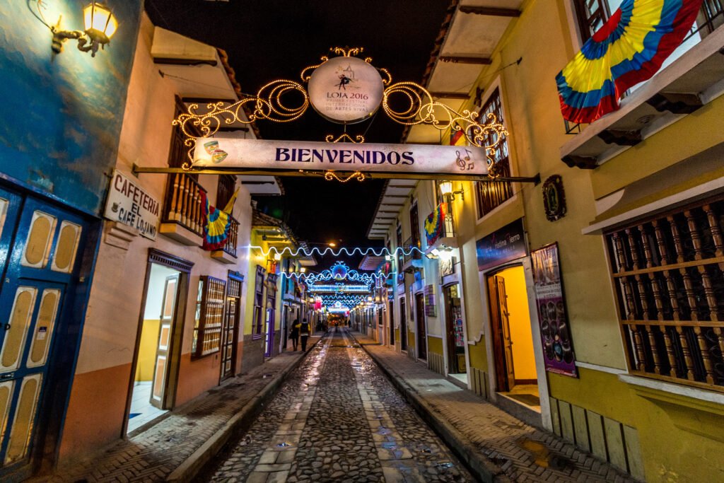 Lourdes Street is lit up at night, with colourful buildings and cobbles, in Loja, Ecuador