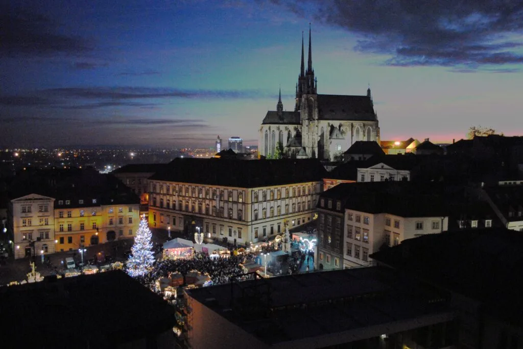 The cathedral of Saint Peter and Paul towers over Zlny Trh covered in snow in Czechia. Wheely Tyred Brno Christmas markets