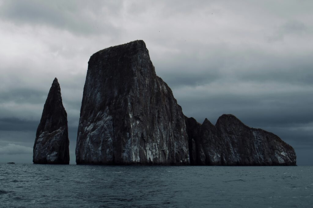 Kicker Rock, or Leon Dormido, is a huge rock formation towering over the Pacific Ocean on a grey dat, near San Cristobal, Galapagos, Ecuador