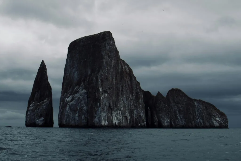 Kicker Rock, or Leon Dormido, is a huge rock formation towering over the Pacific Ocean on a grey dat, near San Cristobal, Galapagos, Ecuador
