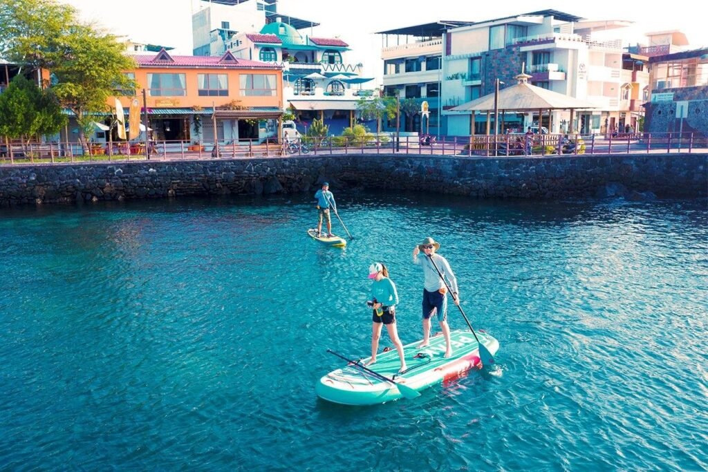People paddle board in a harbor on San Cristobal, Galapagos, Ecuador