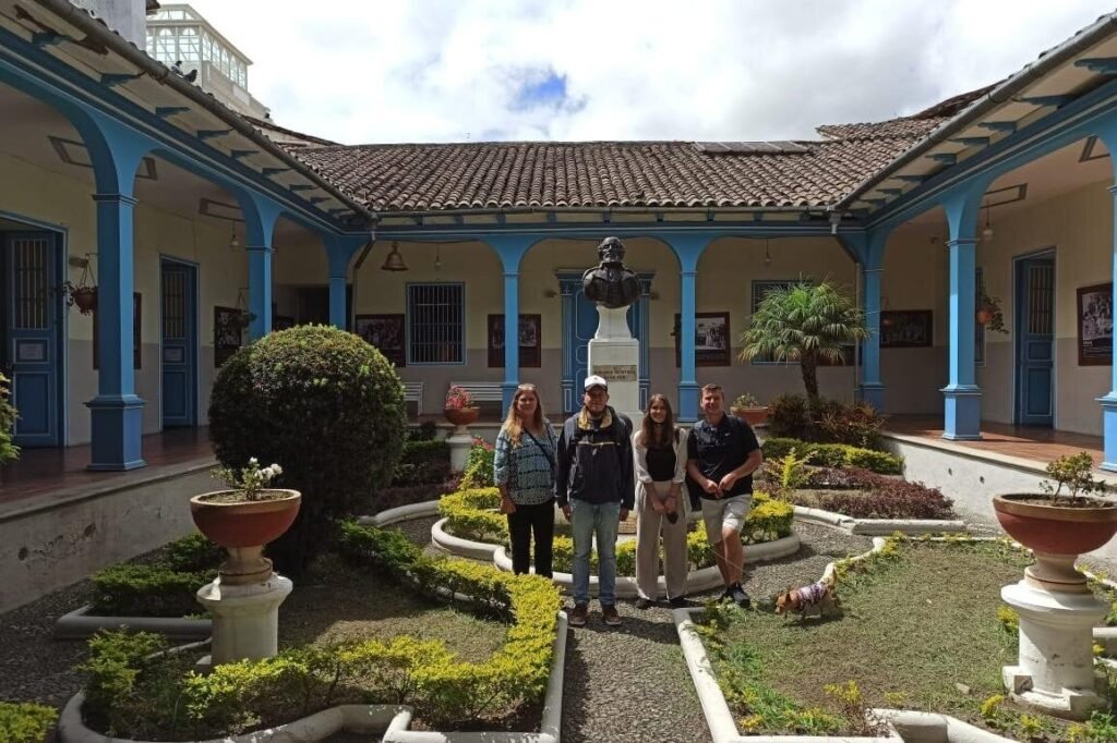 A small group of people stand in the courtyard of a colonial house in Loja, Ecuador